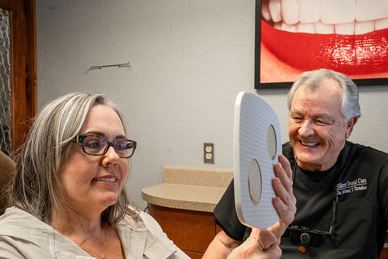 Paitent looking into a mirror after dental implant