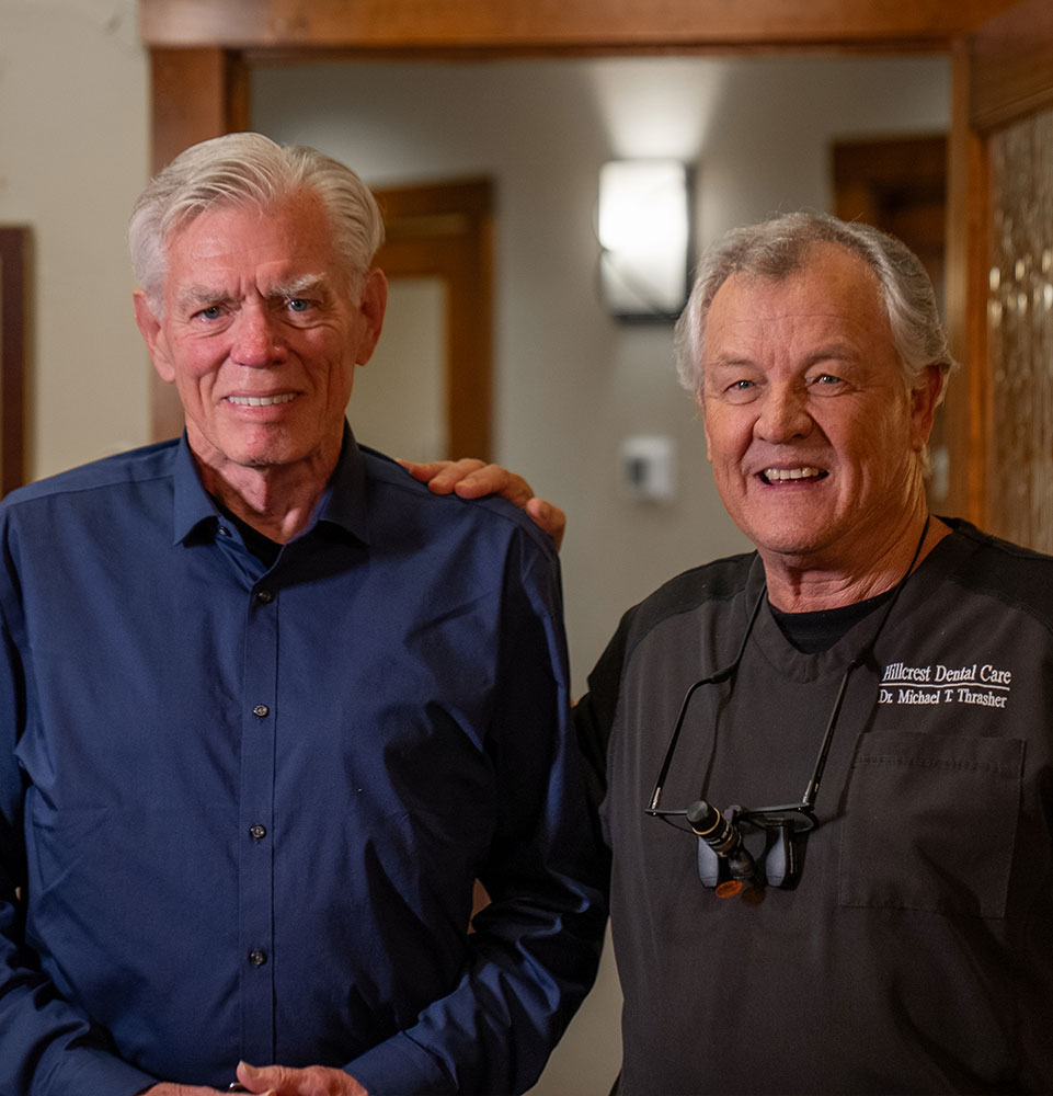 man with new dental implants blue shirt